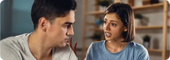 Casal discutindo, a mulher com expressão de raiva ou frustração falando com o homem, que está olhando para o lado.